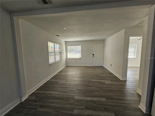 unfurnished room featuring a textured ceiling, ceiling fan, and dark wood-type flooring