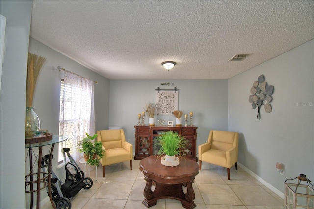 sitting room with a textured ceiling and light tile patterned flooring