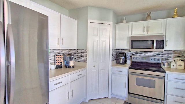 kitchen featuring white cabinets, appliances with stainless steel finishes, and decorative backsplash