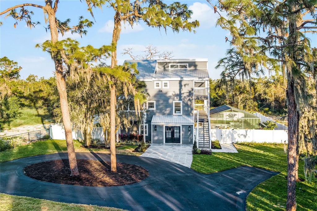 view of front of home featuring a balcony and a front yard