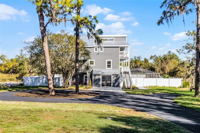 back of house featuring a lawn and a balcony