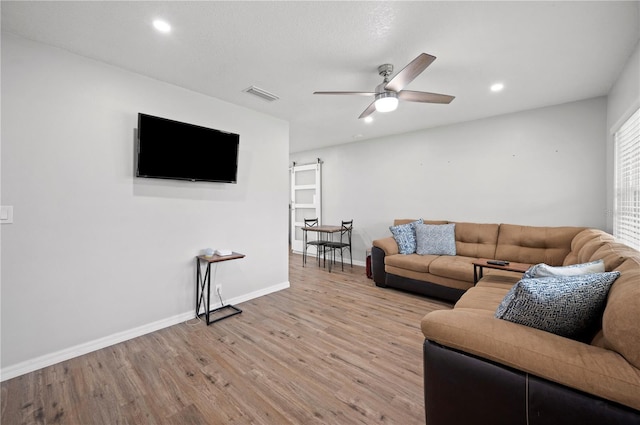 living room featuring ceiling fan and light wood-type flooring