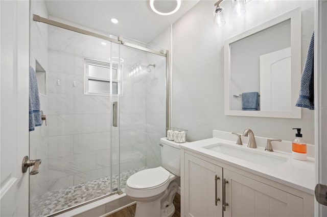 bathroom featuring wood-type flooring, vanity, toilet, and an enclosed shower