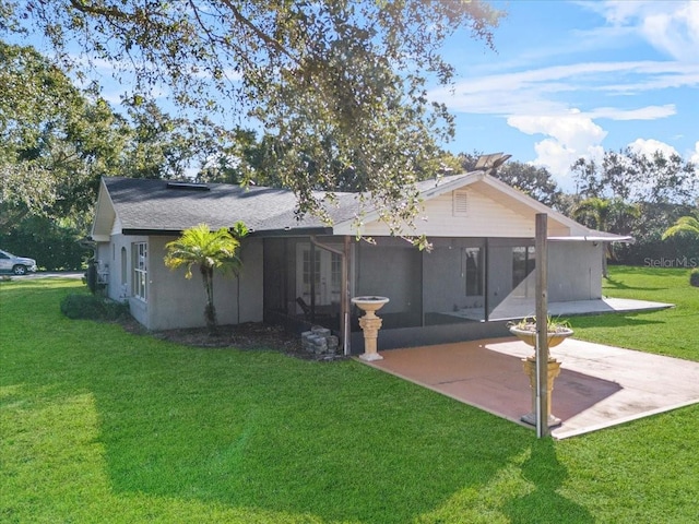 rear view of house featuring a patio, a lawn, and a sunroom