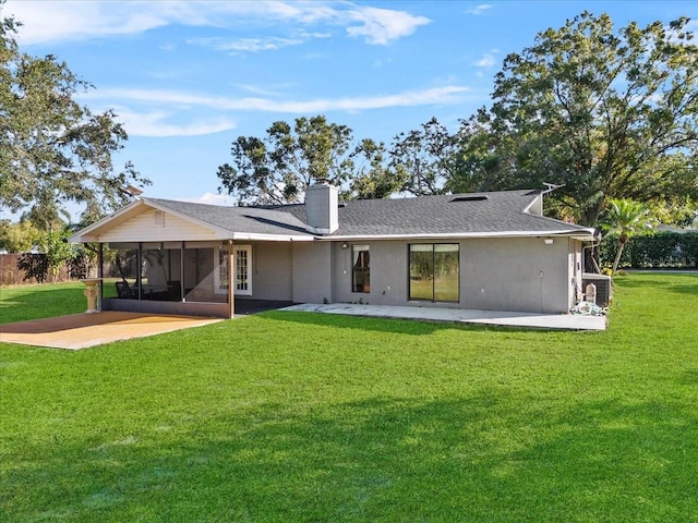 rear view of property featuring a sunroom, a yard, and a patio