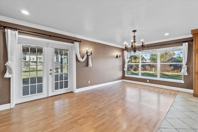 unfurnished dining area with light hardwood / wood-style floors, an inviting chandelier, and crown molding