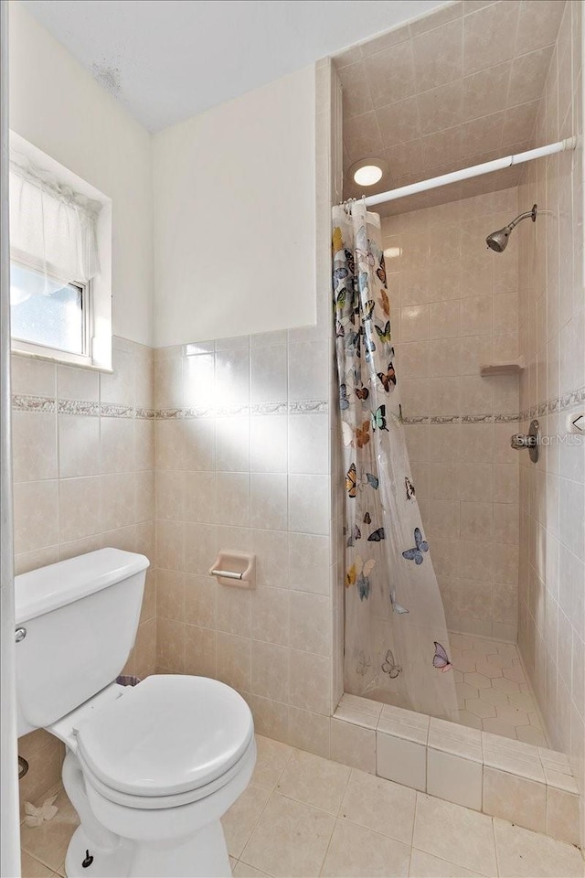 bathroom featuring a shower with shower curtain, tile patterned floors, tile walls, and toilet