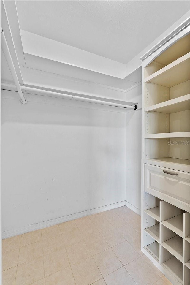 walk in closet with light tile patterned floors