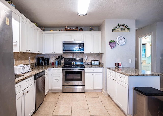 kitchen featuring kitchen peninsula, stainless steel appliances, white cabinets, and stone counters