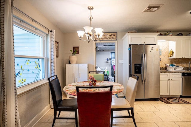 dining area with light tile patterned floors and an inviting chandelier