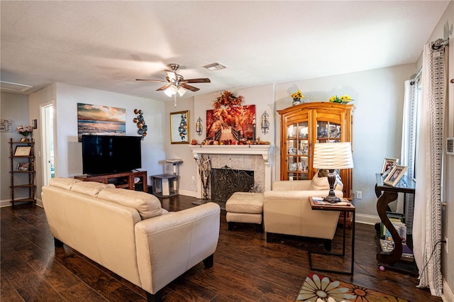 living room featuring a fireplace, dark hardwood / wood-style flooring, and ceiling fan