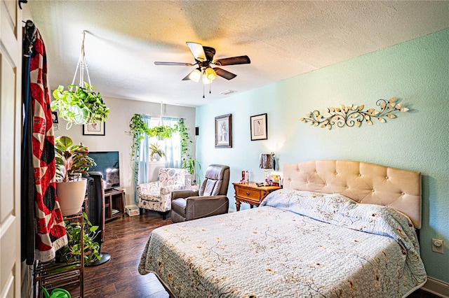 bedroom featuring a textured ceiling, ceiling fan, and dark wood-type flooring