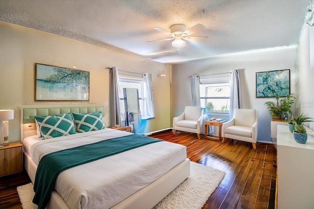 bedroom featuring ceiling fan, dark hardwood / wood-style flooring, and a textured ceiling