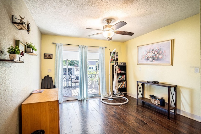 miscellaneous room featuring ceiling fan, dark hardwood / wood-style flooring, and a textured ceiling