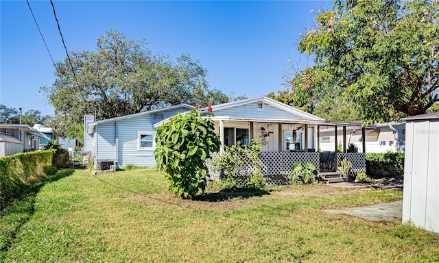 exterior space featuring covered porch, a yard, and central AC