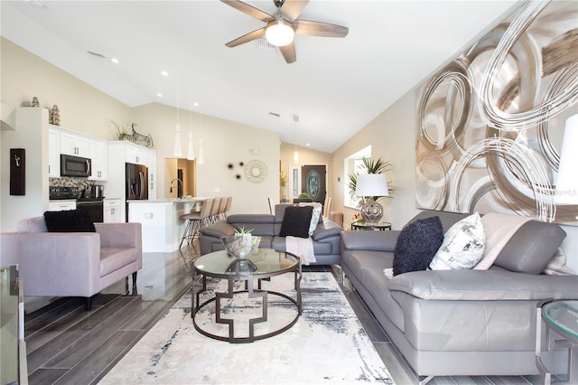 living room with dark hardwood / wood-style floors, vaulted ceiling, sink, and ceiling fan