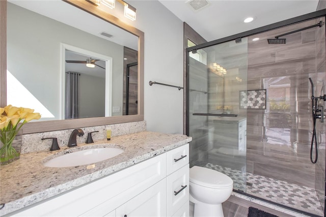 bathroom featuring vanity, toilet, and a shower with door