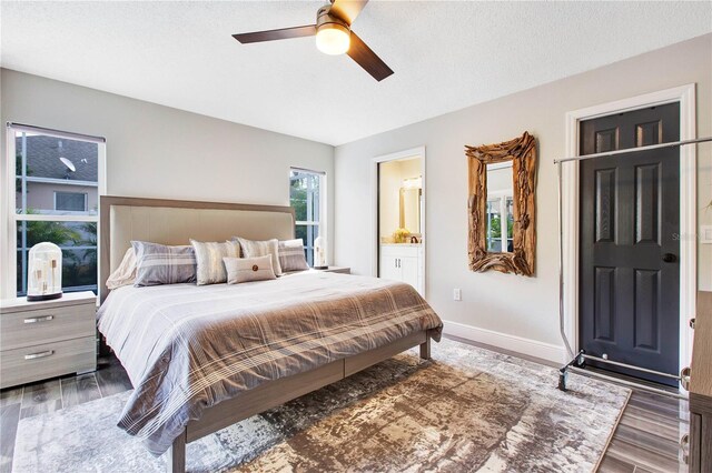 bedroom with dark hardwood / wood-style flooring, connected bathroom, a textured ceiling, and ceiling fan