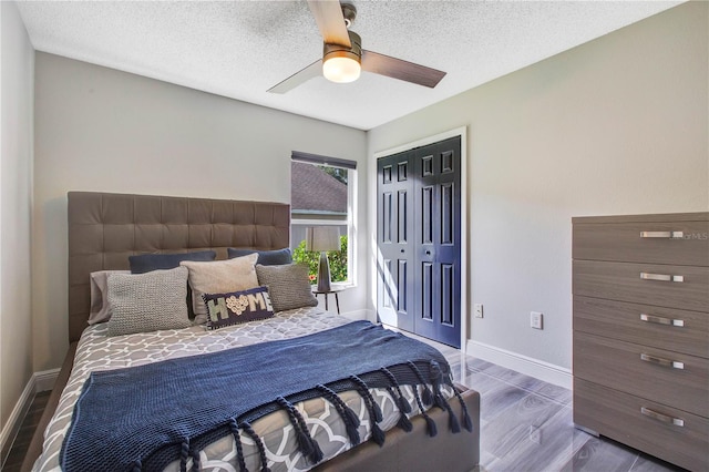 bedroom with dark hardwood / wood-style flooring, ceiling fan, a closet, and a textured ceiling