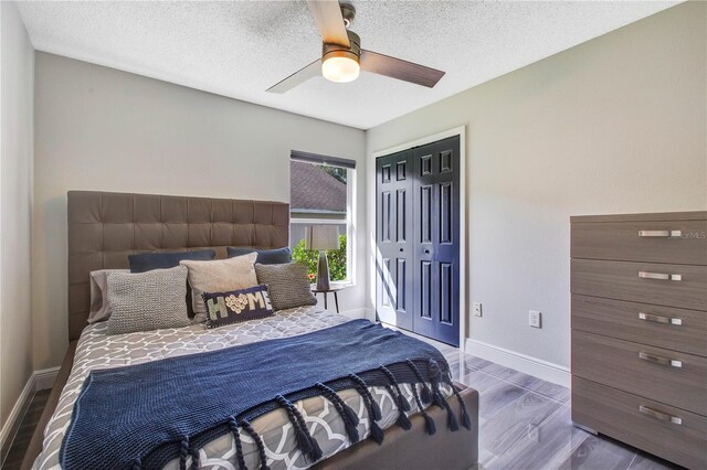 1591 Forest Hills Ln, Haines City, FL 33844 - bedroom featuring wood finished floors, a closet, baseboards, a ceiling fan, and a textured ceiling