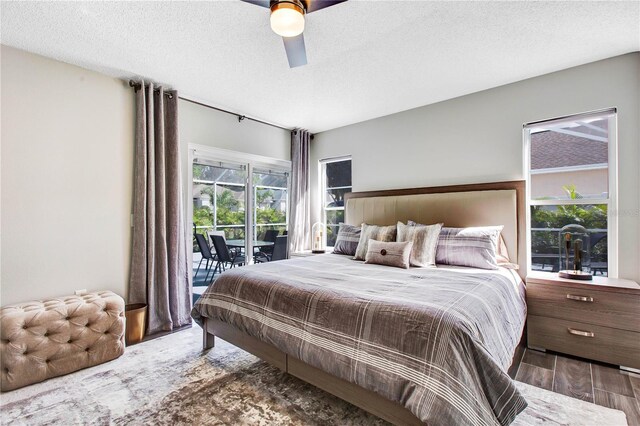 1591 Forest Hills Ln, Haines City, FL 33844 - bedroom with access to exterior, wood finished floors, a textured ceiling, and a ceiling fan
