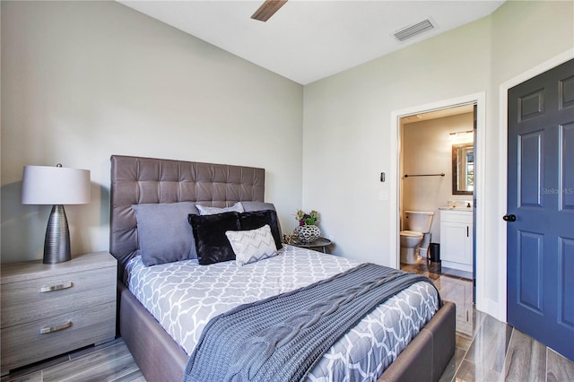 bedroom featuring ensuite bathroom and light hardwood / wood-style flooring