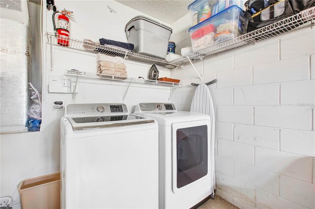 1591 Forest Hills Ln, Haines City, FL 33844 - laundry area featuring separate washer and dryer, concrete block wall, and a textured ceiling