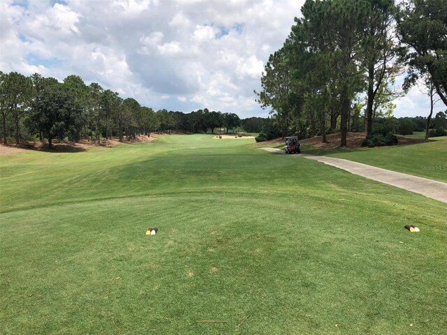 1591 Forest Hills Ln, Haines City, FL 33844 - surrounding community with view of golf course, a yard, and view of wooded area