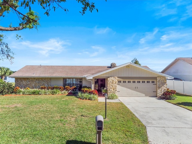 ranch-style home with driveway, a garage, stone siding, fence, and a front yard