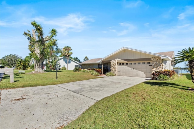 view of front of house with a garage, stone siding, a front lawn, and concrete driveway