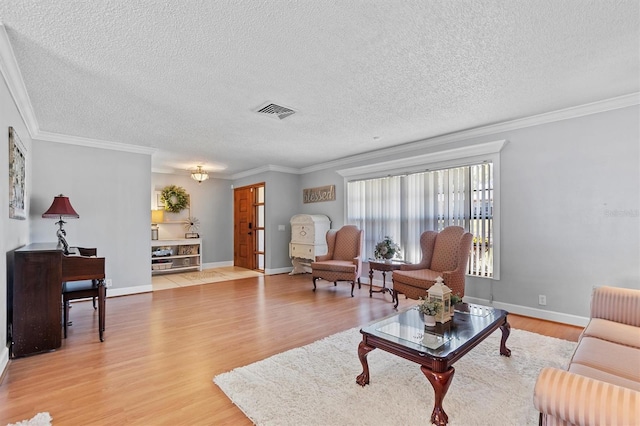 living area featuring a textured ceiling, wood finished floors, visible vents, and crown molding