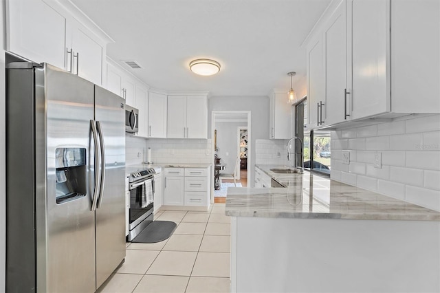 kitchen featuring light tile patterned floors, a peninsula, a sink, visible vents, and appliances with stainless steel finishes