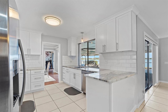 kitchen featuring light stone counters, light tile patterned floors, appliances with stainless steel finishes, white cabinets, and a sink