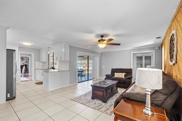 living room featuring light tile patterned floors, visible vents, and a ceiling fan