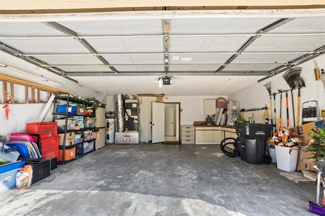 garage with a garage door opener, water heater, and heating unit