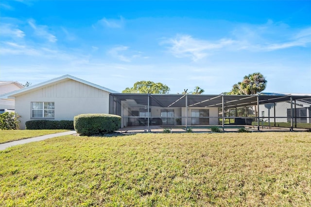 view of front facade with glass enclosure and a front lawn