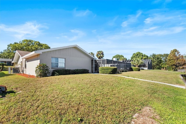 view of home's exterior featuring a yard and glass enclosure