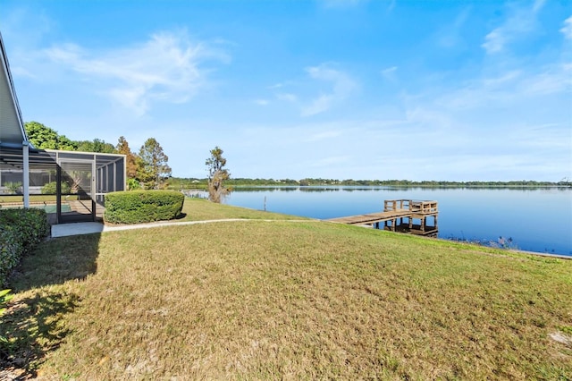 view of dock featuring a water view, glass enclosure, and a lawn