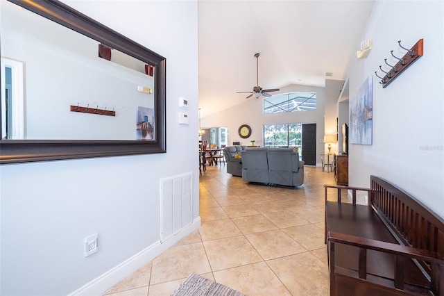 hallway with light tile patterned flooring and vaulted ceiling