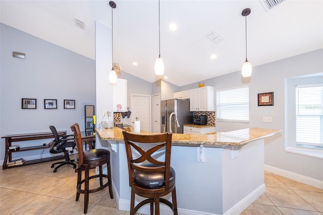 kitchen featuring kitchen peninsula, vaulted ceiling, plenty of natural light, and hanging light fixtures