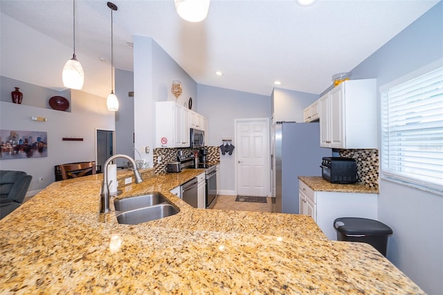 kitchen featuring sink, decorative backsplash, decorative light fixtures, kitchen peninsula, and stainless steel appliances