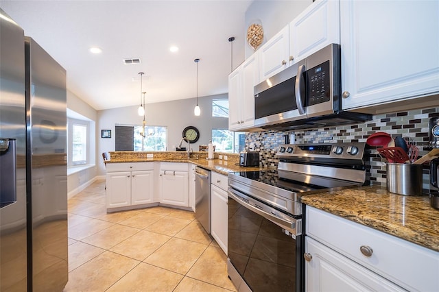 kitchen featuring lofted ceiling, tasteful backsplash, decorative light fixtures, white cabinetry, and stainless steel appliances