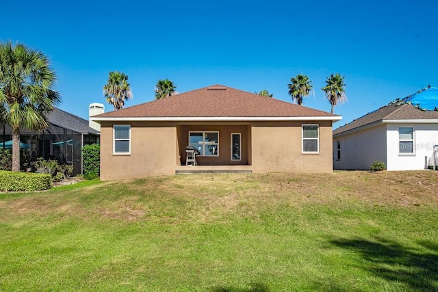 rear view of property featuring a lawn