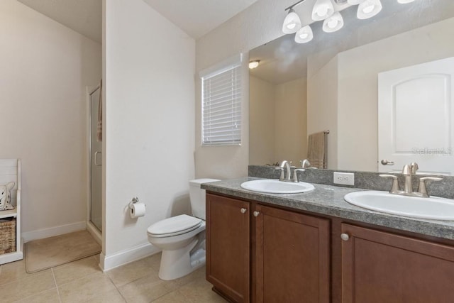 bathroom featuring tile patterned floors, toilet, vanity, and walk in shower