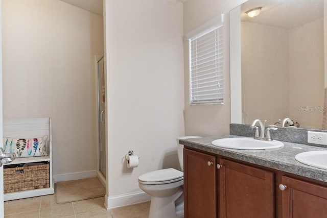 bathroom with toilet, vanity, tile patterned floors, and a shower with shower door