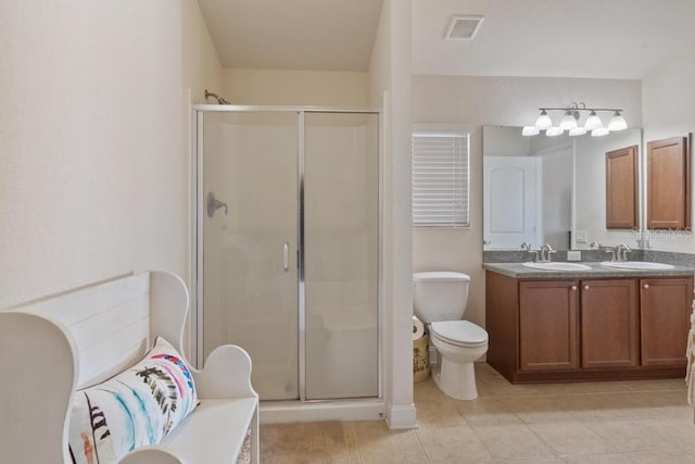 bathroom with tile patterned flooring, vanity, toilet, and a shower with shower door