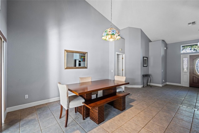 dining space with tile patterned flooring and high vaulted ceiling