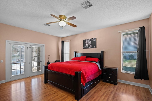 bedroom with access to exterior, ceiling fan, light hardwood / wood-style flooring, and a textured ceiling