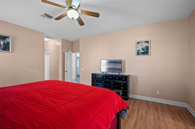 bedroom with wood-type flooring, a textured ceiling, and ceiling fan