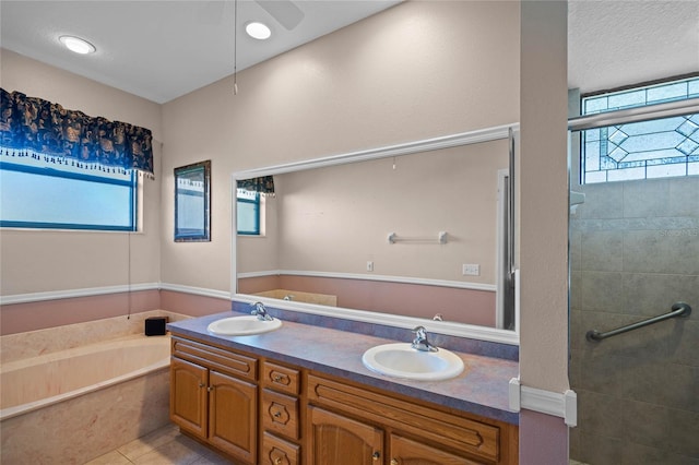 bathroom with tile patterned floors, ceiling fan, vanity, and independent shower and bath